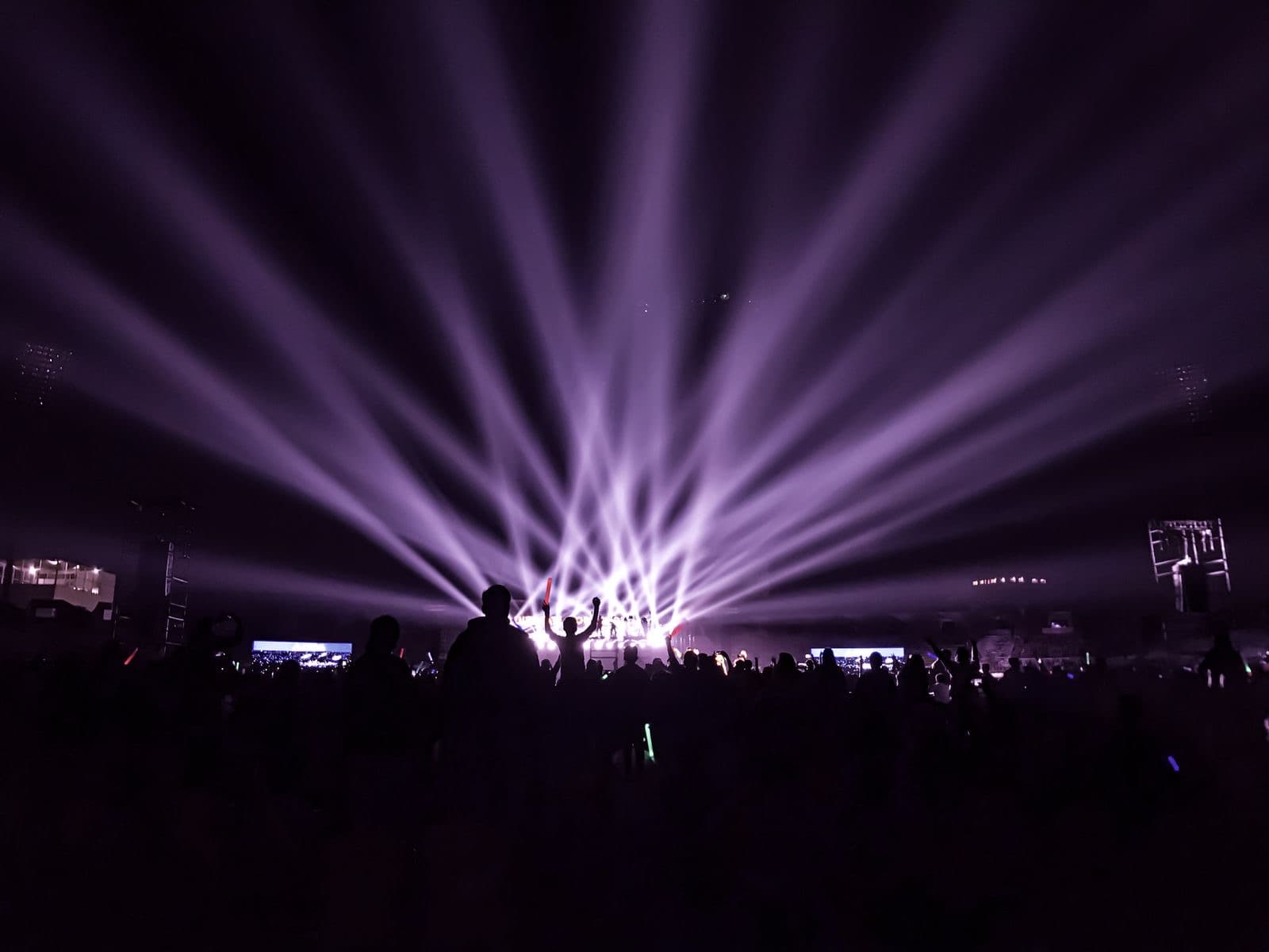 Beams of colored light over a crowd at a night concert